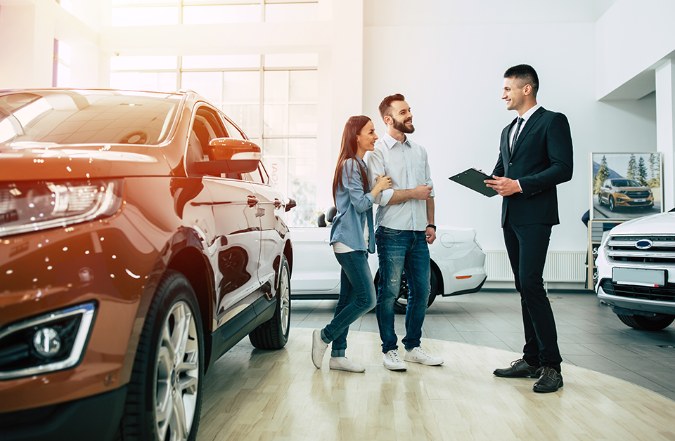 Woman and man buying vehicle at dealership