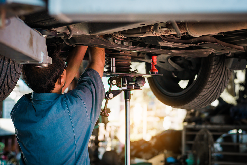 Auto worker, fixing a vehicle.