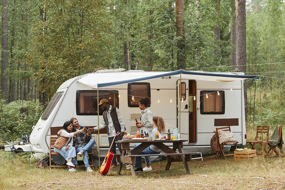 Friends relaxing outside their camper.