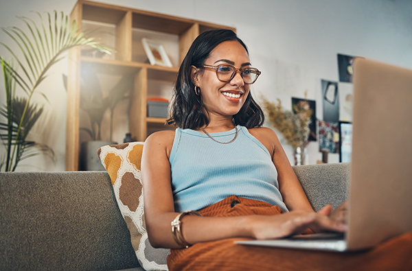 Women sitting on Livingroom couch working on laptop