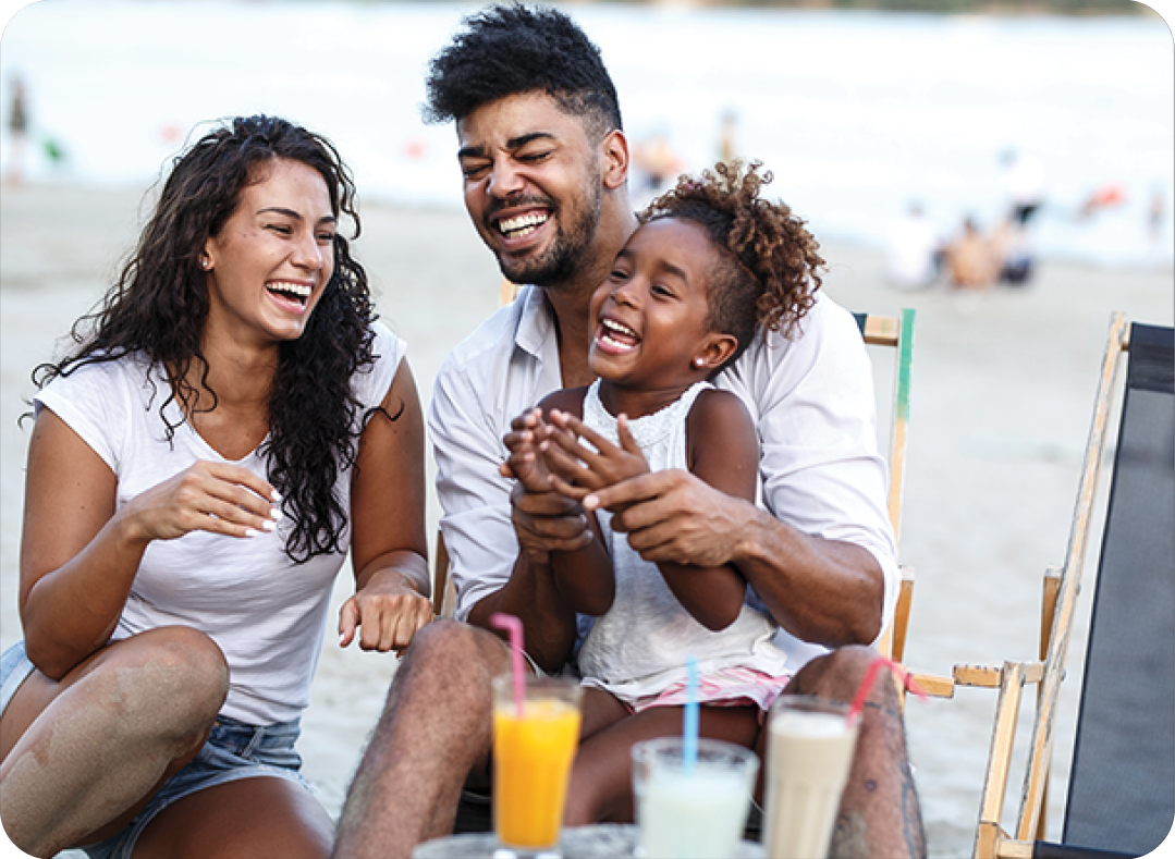 family sitting and relaxing at the beach on beautiful summer day