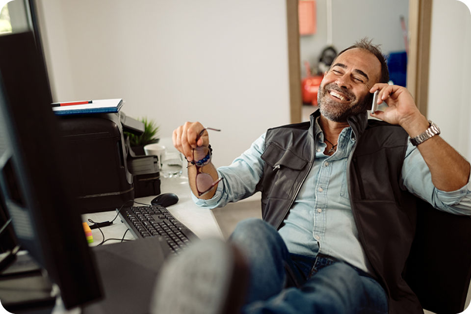 man sitting at desk on mobile phone