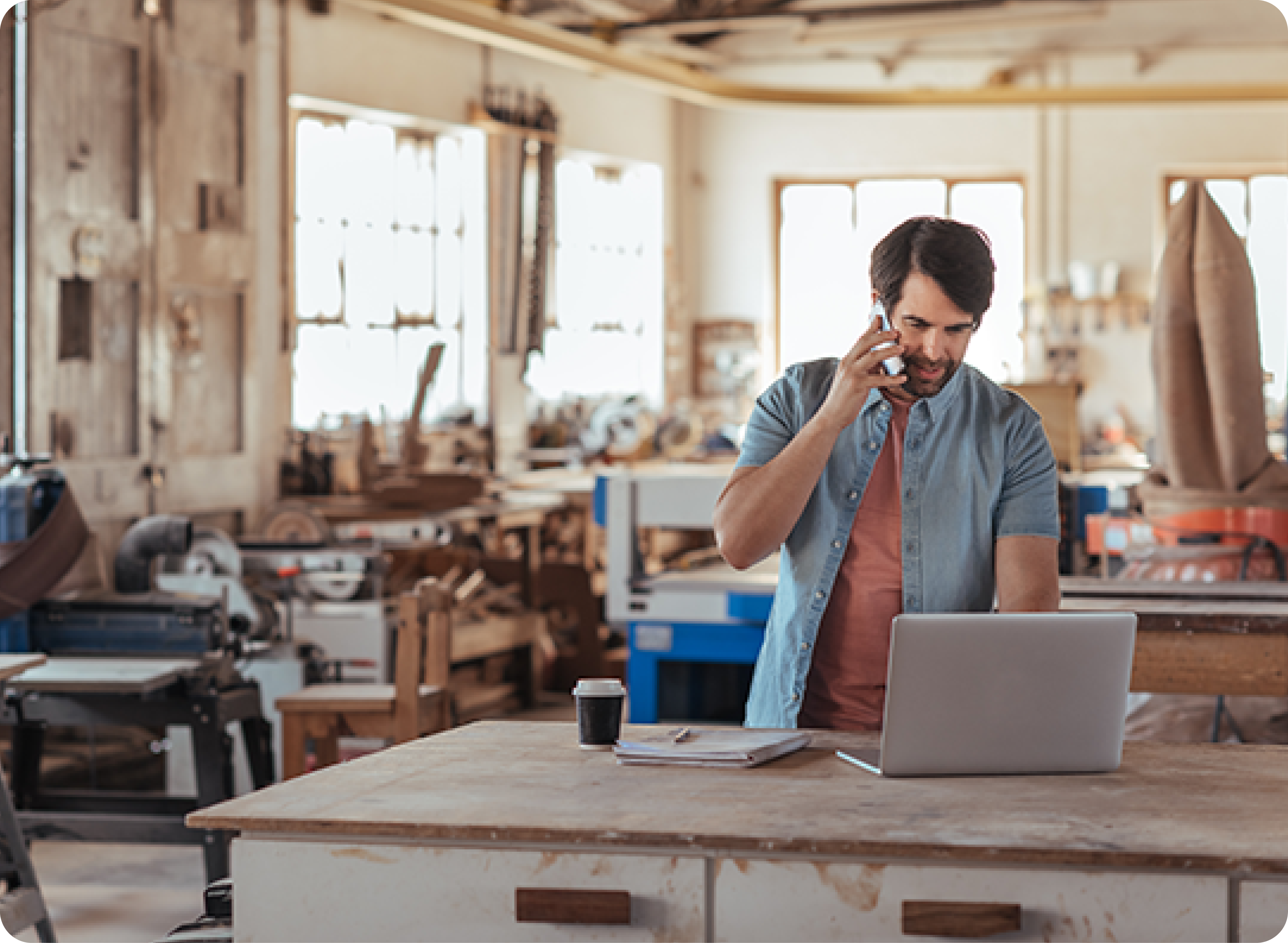 Man working in workshop talking on phone