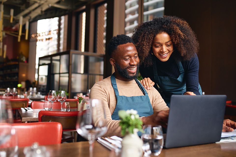 small business owners working on laptop in cafe