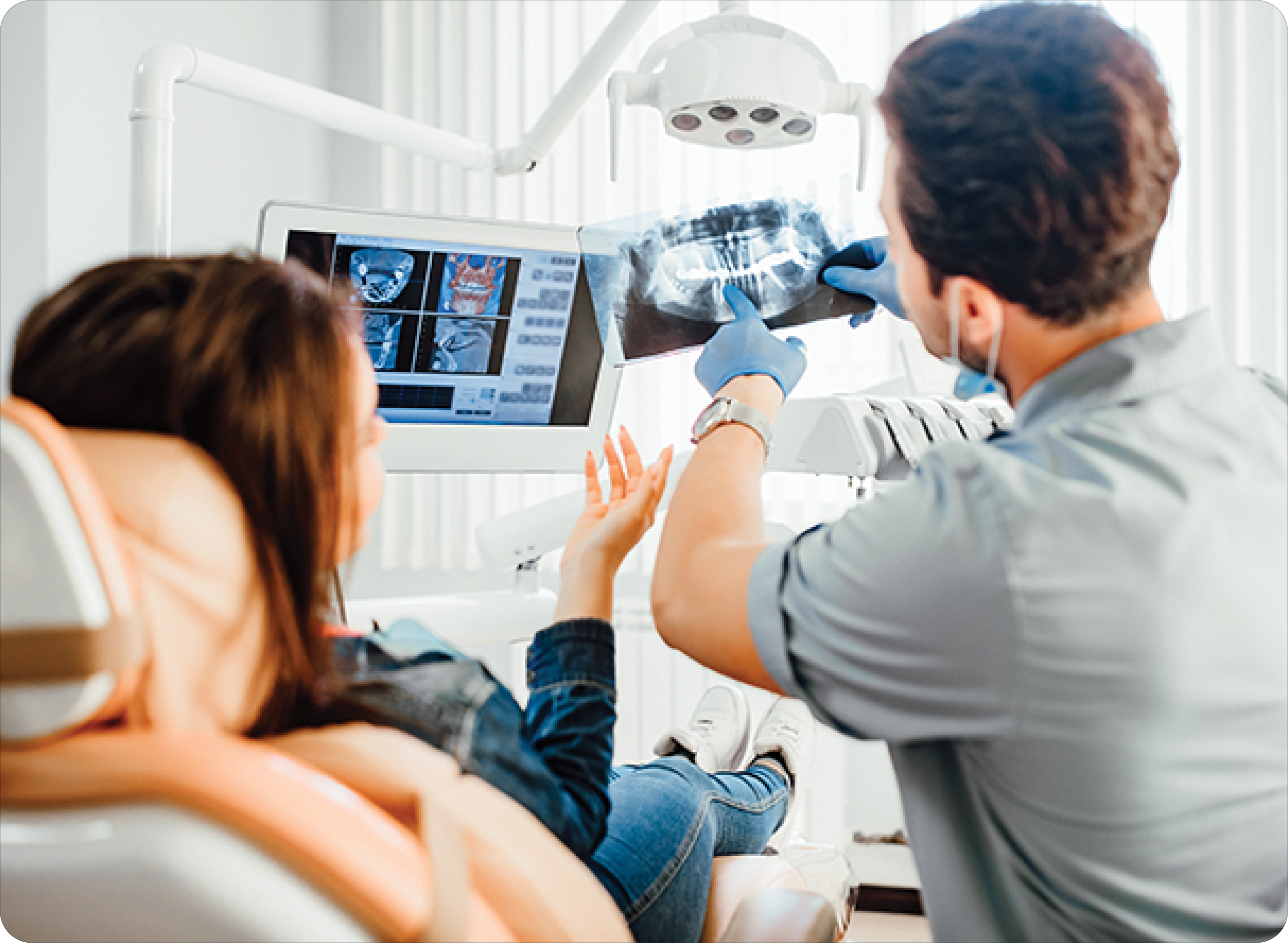 male dentist showing teeth x-ray to female patient at dental clinic office