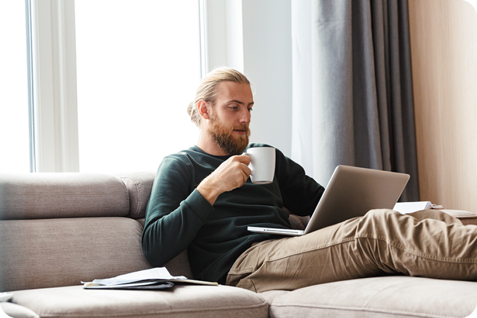 Man sitting on couch drinking out of mug