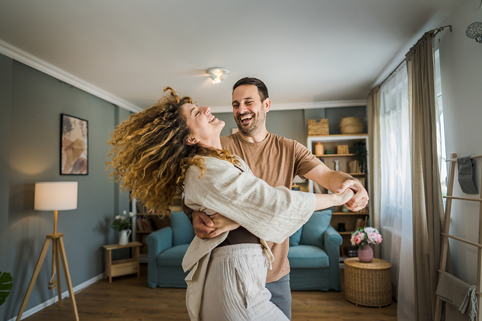 Happy couple dancing in Livingroom.