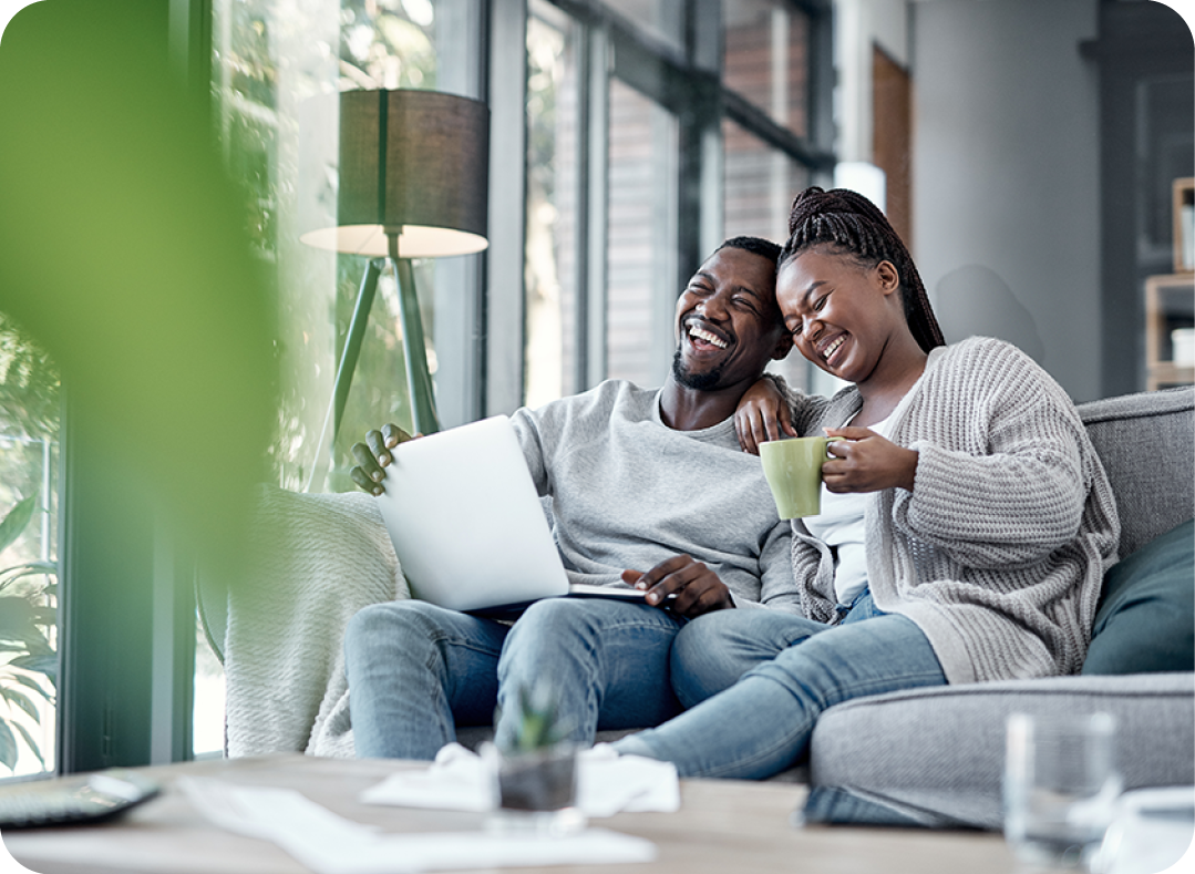 Couple smiling and working on laptop